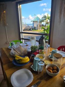 uma mesa de madeira com bananas e outros alimentos em La Plage Residence em Crève Coeur
