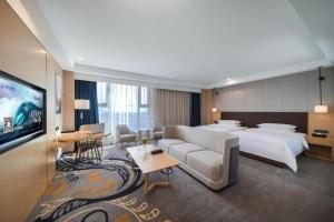 a hotel room with a large bed and a television at Venus Royal Hotel Ordos Yijinhuoluo Banner Olympic in Ordos