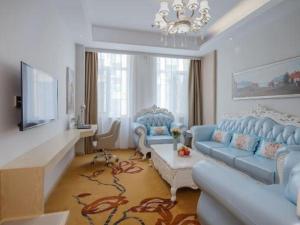 ein Wohnzimmer mit blauen Sofas und einem Fernseher in der Unterkunft Vienna Hotel Shandong Yuncheng Shuihu Road Hoahancheng in Yuncheng