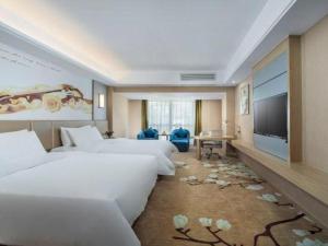 a hotel room with three beds and a flat screen tv at Vienna Hotel Fuzhou Changle Shouzhan Hangcheng Metro Station in Fuzhou +127 photos