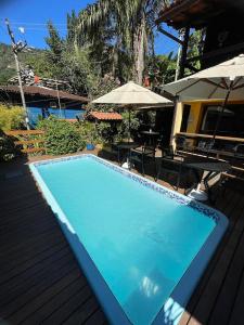 a large blue swimming pool next to a house at Canoa Ilha Grande in Abraão