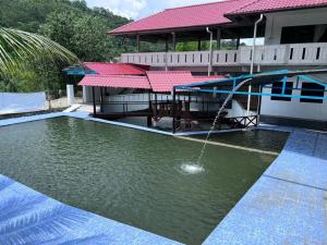 a house with a swimming pool with a water fountain at Langat Escape in Hulu Langat