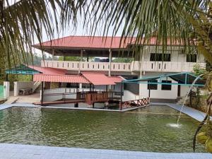 a building with a swimming pool in front of a building at Langat Escape in Hulu Langat