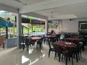 a dining room with tables and chairs and windows at Langat Escape in Hulu Langat