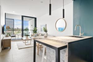 une cuisine avec un évier et un salon dans l'établissement Chic 1-Bed Escape in Fremantle with Parking, à North Fremantle 29 autres photos