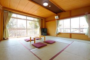 a living room with a table and two windows at Greenchair AMANO in Yamanakako