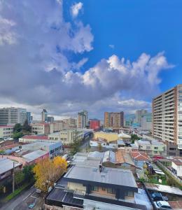 un paisaje urbano de una ciudad con edificios y nubes en Centro Temuco 4, en Temuco 9 fotos más