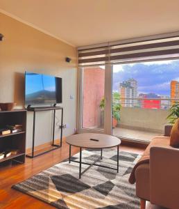 Una sala de estar con televisión y una mesa de café. en Centro Temuco 4, en Temuco