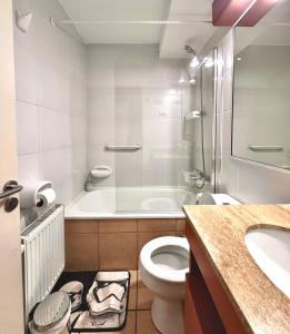 a bathroom with a tub and a toilet and a sink at Centro Temuco 4 in Temuco +9 photos