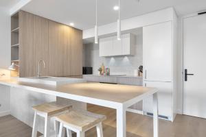 a kitchen with a counter with stools in it at Spacious 2-Bed Apartment in North Fremantle in North Fremantle