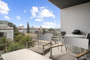 a balcony with tables and chairs and a large window at Spacious 2-Bed Apartment in North Fremantle in North Fremantle