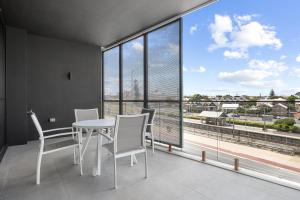 a dining room with a table and chairs and large windows at Bright 1-Bedroom Escape with Private BBQ in North Fremantle