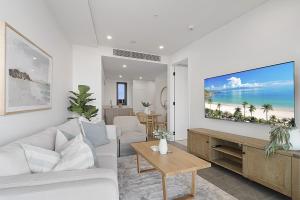 a living room with a couch and a tv on a wall at Bright 1-Bedroom Escape with Private BBQ in North Fremantle