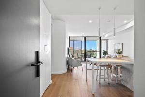 a kitchen and dining room with a table and chairs at Stylish 2-Bed Unit with Views & Rooftop Access in North Fremantle +37 photos