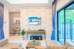 una sala de estar con una pared de piedra en Gallery Na Jomtien, en Na Jomtien