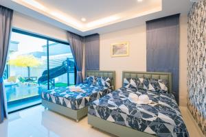 2 camas en un dormitorio con balcón en Gallery Na Jomtien, en Na Jomtien 26 fotos más