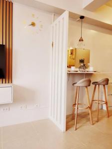 a kitchen with two bar stools and a counter at Preum Properties Tagaytay in Tagaytay
