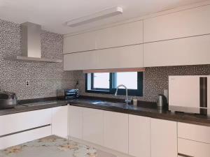 a kitchen with white cabinets and a sink at Sogil inner Forest in Jeju +15 photos