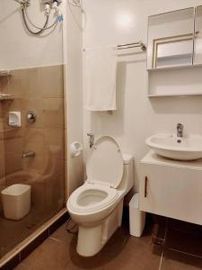 a white bathroom with a toilet and a sink at Preum Properties Tagaytay in Tagaytay +17 photos