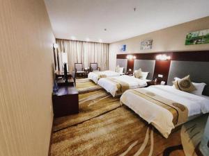 ein Hotelzimmer mit drei Betten in der Unterkunft Wanxiang Hotel in Maluan + 147 Fotos