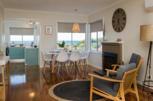 a living room with a table and chairs and a clock at Penguin Beach House in Penguin