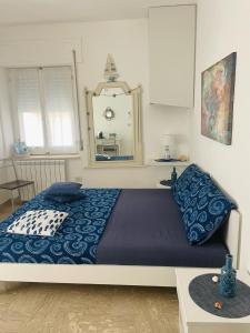 a bedroom with a bed with blue sheets and a mirror at SoverHouse affittacamere a Soverato Marina in Soverato Marina
