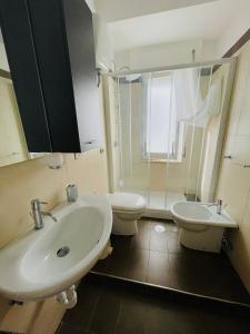 a bathroom with two toilets and a sink and a shower at SoverHouse affittacamere a Soverato Marina in Soverato Marina