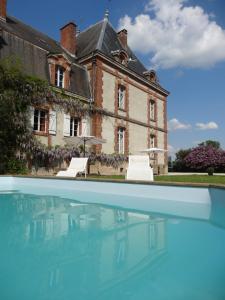 een oud huis met een zwembad ervoor bij Château de Nettancourt in Nettancourt