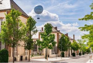 a hot air balloon is flying over a street at WIFI, Parking, AV champagne, 5min Mercier, Moët Ch in Épernay
