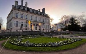 a large building with a circle of flowers in front of it at WIFI, Parking, AV champagne, 5min Mercier, Moët Ch in Épernay