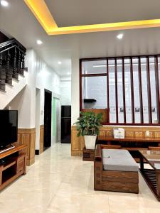 a living room with a tv and a potted plant at Jerry house - Private House in the City center in Hue