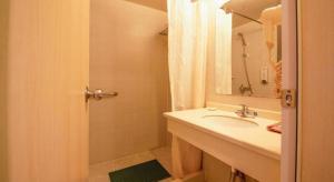 ein Badezimmer mit Waschbecken und Dusche mit Spiegel in der Unterkunft Jinjiang Inn Xi'an Huimin Street Zhonglou Metro Station in Xi'an + 202 Fotos