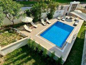 an overhead view of a swimming pool with chairs and an umbrella at Oregano Side in Side