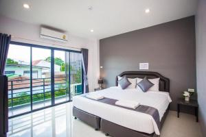 une chambre avec un grand lit et un balcon dans l'établissement The Bed Hotel Phitsanulok, à Sathani Phitsanulok