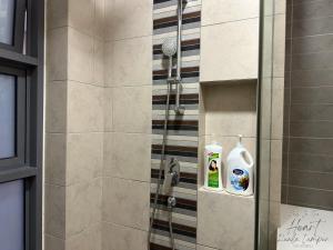 a bathroom with a shower with a bottle of soap at Cozy Minimalist Condo In The Heart of Kuala Lumpur City 1BR in Kuala Lumpur +20 photos