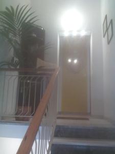 a hallway with a door and stairs with a plant at Appartamento Vacanze in Stintino