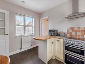 a kitchen with a counter top and a stove top oven at Primrose Cottage - Uk48563  +11 photos