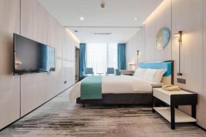 Una habitación de hotel con una cama y un televisor de pantalla plana. en Golden Central Hotel Shenzhen, en Shenzhen 259 fotos más