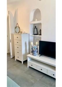 a living room with a tv and a dresser at The Fig Tinos in Triandáros