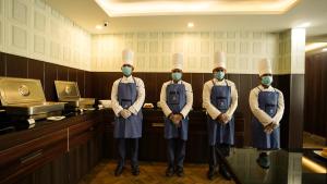 a group of four chefs wearing masks in a kitchen at Jashn Wellness Resort Lucknow in Lucknow