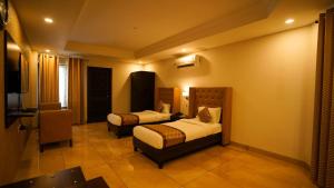 a hotel room with two beds and a television at Jashn Wellness Resort Lucknow in Lucknow +13 photos