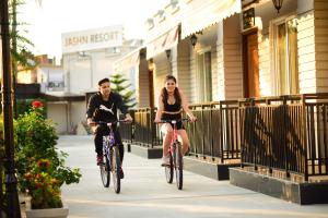 a man and a woman riding bikes down a sidewalk at Jashn Wellness Resort Lucknow in Lucknow