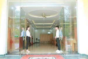 two men standing in a glass case in a room at Hotel Thanh loi in Mỹ Ðuc