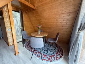 a small table with chairs and a vase of flowers at Zhyluu Suu Resort BozUchuk in Novovoznesenovka