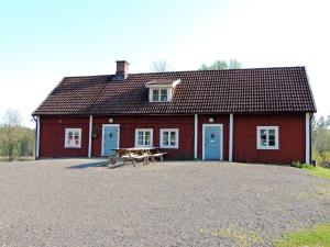 eine rote Scheune mit einem Picknicktisch davor in der Unterkunft Hjärtasjöstugor in Lönsboda