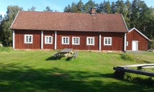 a red house with a bench in front of it at Hjärtasjöstugor in Lönsboda