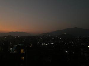 a city skyline at night with mountains in the background at Davu Gallery Cafe in Kathmandu