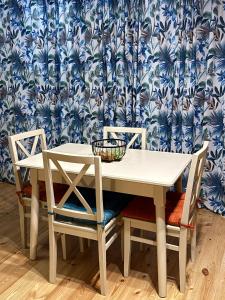 a white table and chairs with a blue and white wallpaper at Mtiskari cottage in Utsera in Utsera