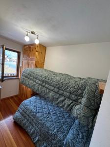 a bedroom with two beds and a window at Casa Gatto in Auronzo di Cadore