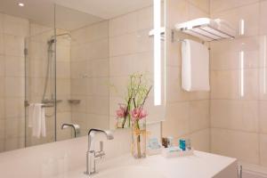 a bathroom with a sink and a mirror at Novotel Abu Dhabi Al Bustan in Abu Dhabi